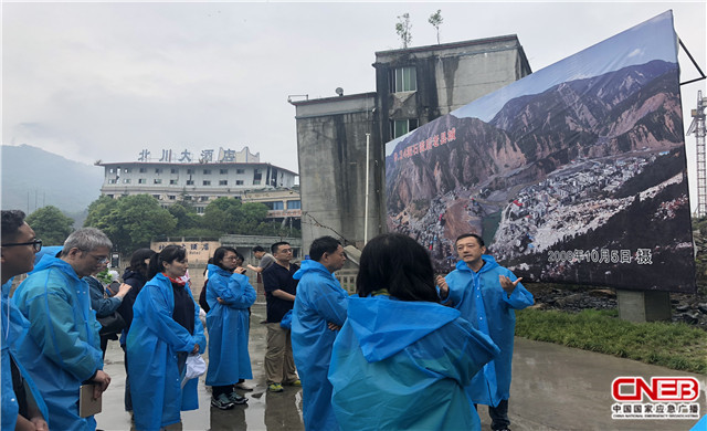 参演人员在北川地震遗址万人纪念碑前聆听曾经参与报道的同事讲述